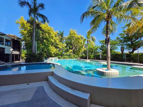 a swimming pool with a palm tree in the middle at BALAI Condominiums in Lusong
