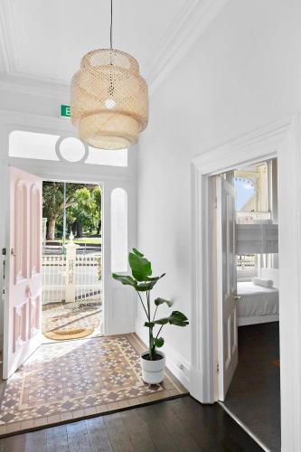 a hallway with a potted plant and a chandelier at Fitzroy Private Rooms - 132 Nicholson Homestay in Melbourne