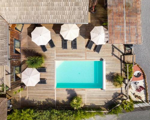 une vue aérienne d'une piscine avec des parasols dans l'établissement Ô Lac, à Lacanau
