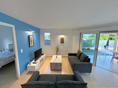 Una sala de estar con dos sofás y un televisor. en Le Saphir - Vue piscine, Terrasse, Destreland, en Baie-Mahault