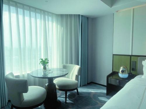 a hotel room with a table and chairs and a bed at Shu Guang International Hotel in Nanjing