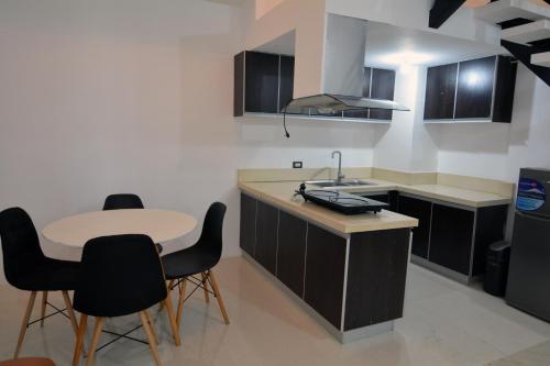 a kitchen with a table and chairs and a sink at BALAI Condominiums in Lusong