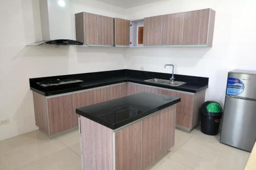 an empty kitchen with a sink and a refrigerator at BALAI Condominiums in Lusong