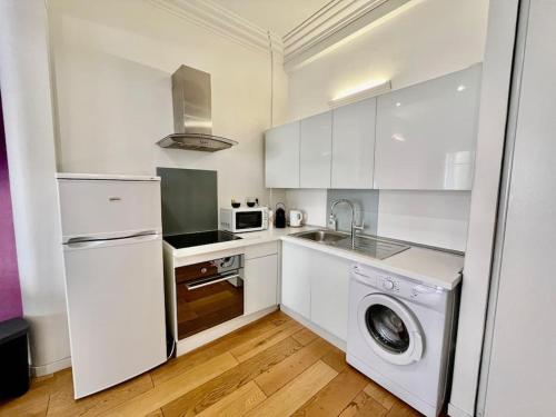 une cuisine blanche avec un lave-linge et un lave-linge dans l'établissement Nice Les palais de la Med, à Nice