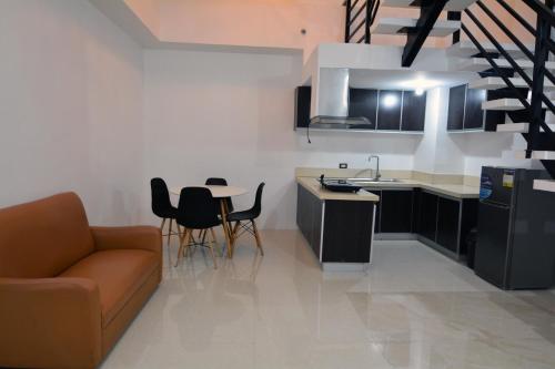a kitchen and living room with a couch and a table at BALAI Condominiums in Lusong