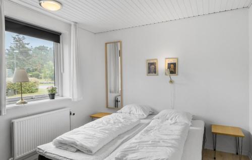 a white bedroom with a bed and a window at Stunning Home In Roslev With Sauna in Glyngøre