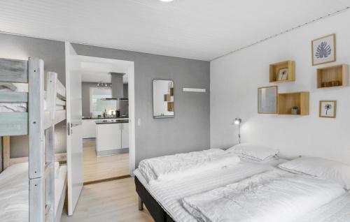 a white bedroom with a bed and a kitchen at Stunning Home In Roslev With Sauna in Glyngøre