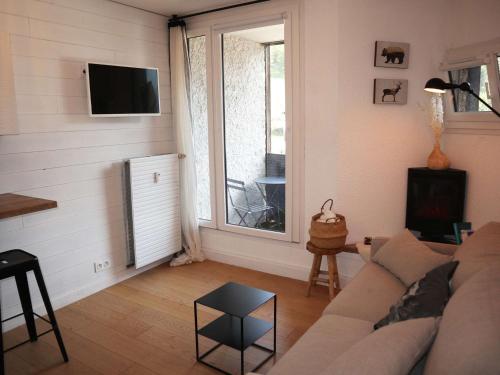 un salon avec un canapé et une fenêtre dans l'établissement Coquet studio skis aux pieds, plein centre, balcon sud - FR-1-322-638, aux Orres