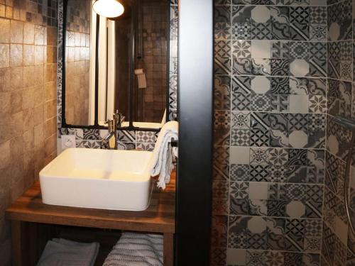 une salle de bain avec un lavabo blanc et un mur carrelé dans l'établissement Coquet studio skis aux pieds, plein centre, balcon sud - FR-1-322-638, aux Orres