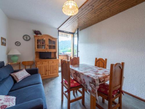 un salon avec une table et un canapé bleu dans l'établissement Les Gets: 2P, proche pistes, garage, navettes - FR-1-802-92, aux Gets