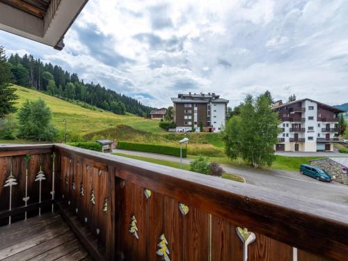 Elle comprend un balcon en bois offrant une vue sur la rue. dans l'établissement Les Gets: 2P, proche pistes, garage, navettes - FR-1-802-92, aux Gets