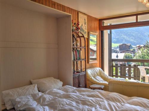 une chambre avec un lit, un canapé et une fenêtre dans l'établissement Studio confortable 4 personnes à Morzine, animaux acceptés et garage privé - FR-1-524-129, à Morzine