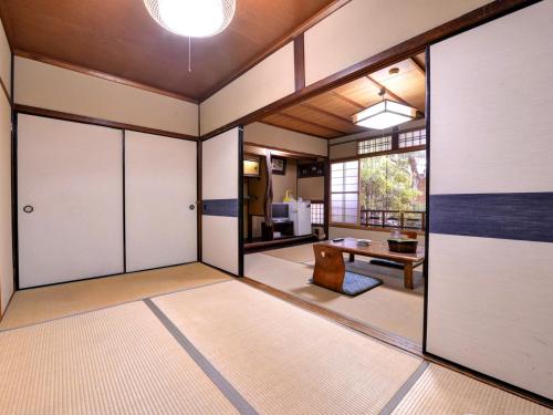 an empty room with sliding doors and a table at Yamamoto Ryokan in Kyoto