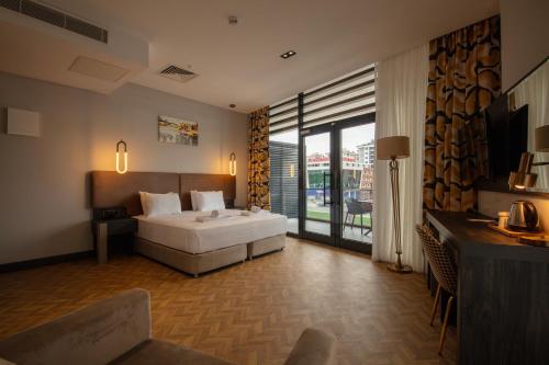 a bedroom with a white bed and a large window at V Center Hotel in Trabzon