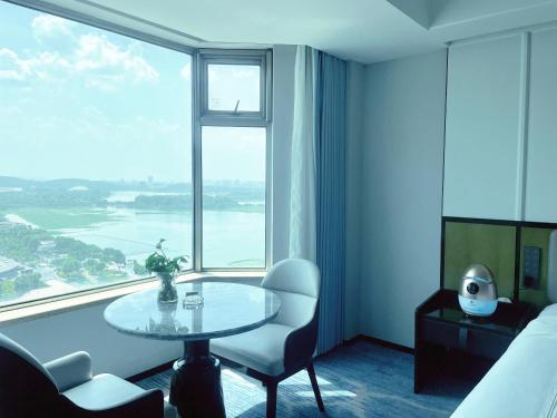 a hotel room with a table and a large window at Shu Guang International Hotel in Nanjing