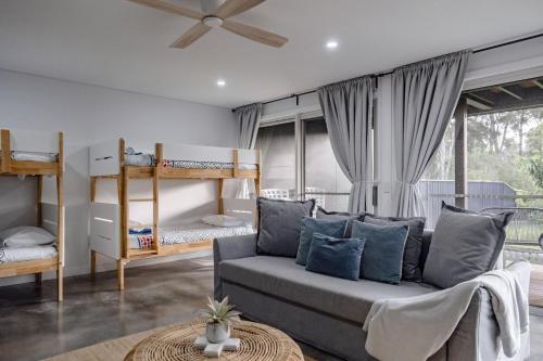 モリーモックにあるPandanas 17B at Mollymook Beachのソファと二段ベッドのあるリビングルーム