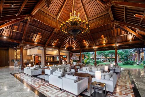 a large lobby with white furniture and a chandelier at Prime Plaza Hotel Sanur – Bali in Sanur