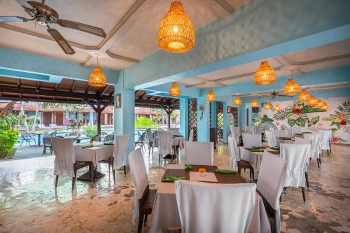 a dining room with tables and chairs and chandeliers at Prime Plaza Hotel Sanur – Bali in Sanur