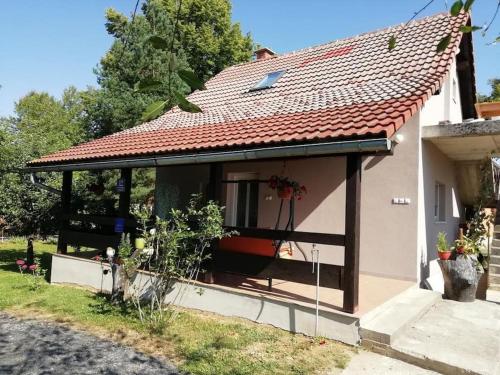 a small house with a red roof at Apartman Adam in Rakovica