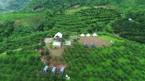 an aerial view of a farm with tents on a hill at Ora Hill Retreat in Cao Phong