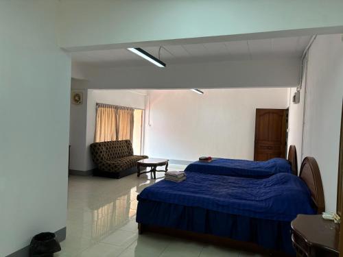a bedroom with a blue bed and a chair at My Hotel Bangkok Noi in Bangkok Noi