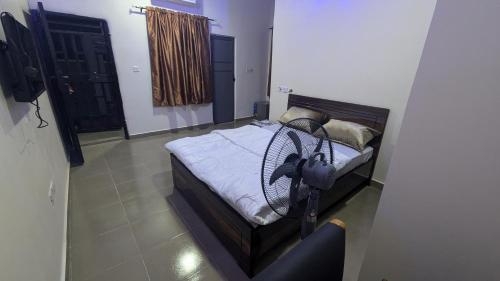 a bedroom with a bed with a fan on it at Nexcon Apartments in Uyo