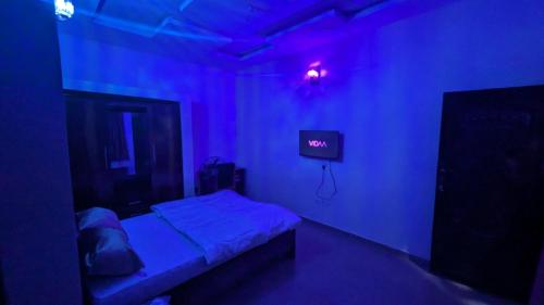 a dark room with a bed and a tv at Nexcon Apartments in Uyo