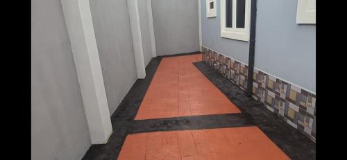 a hallway with an orange floor and white walls at Nexcon Apartments in Uyo