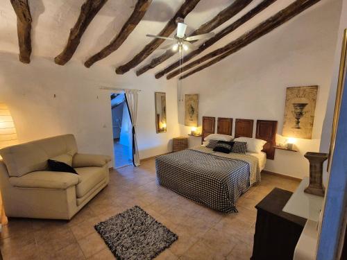 a living room with a bed and a couch at Casa rustica y tranquila en Zarra in Zarra