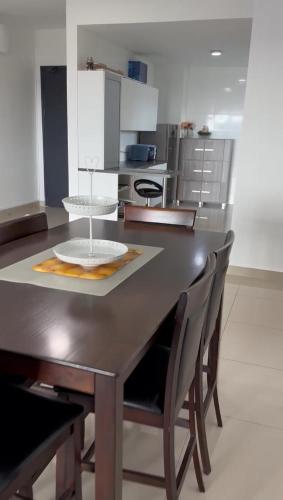 a kitchen with a dark wooden table and chairs at Sandakan Spacious and Comfortable Pool View Condo in Sandakan