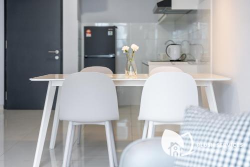 a kitchen with a table and two white chairs at Gaia Residences by Plush in Rawang