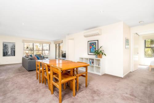 a living room with a wooden table and a couch at Modern 2BR 2BA Apartment Close to City and ANU - Hosted by Canstay in Canberra