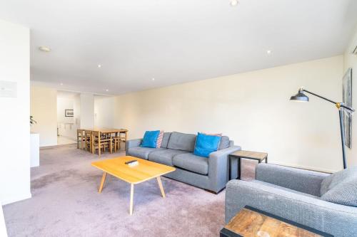 a living room with a couch and a table at Modern 2BR 2BA Apartment Close to City and ANU - Hosted by Canstay in Canberra