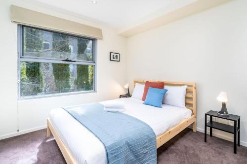 a bedroom with a large bed and a window at Modern 2BR 2BA Apartment Close to City and ANU - Hosted by Canstay in Canberra