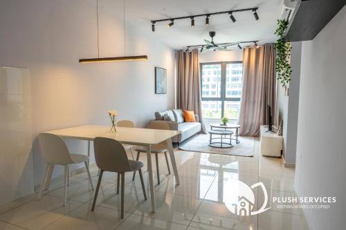 a dining room and living room with a table and chairs at Gaia Residences by Plush in Rawang