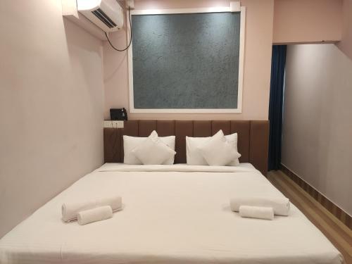 a bedroom with a large white bed with white pillows at The Rividium Hotel in Deoghar