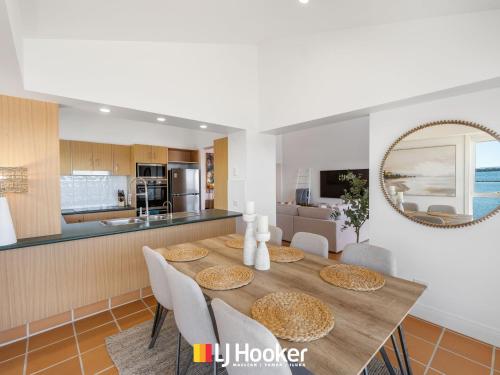 a dining room and kitchen with a table and chairs at Riverview Apartment 2.4 in Iluka
