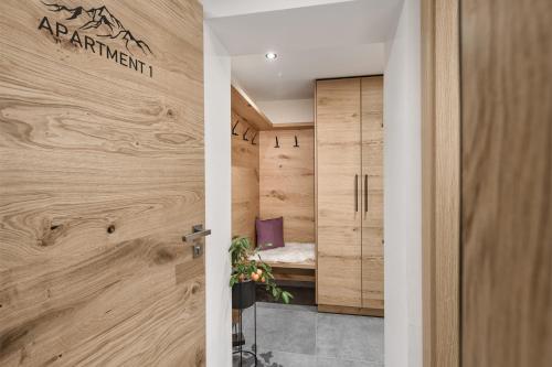drzwi prowadzące do pokoju z drewnianymi ścianami w obiekcie Apartment NH96 inklusive kostenfreiem Eintritt in die Alpentherme w mieście Bad Hofgastein