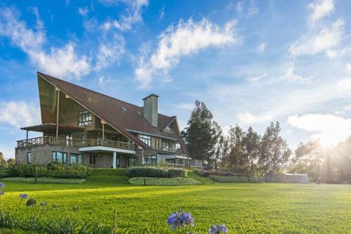 a house on a hill with a green field at Kirimara Woodlands, Nanyuki in Nanyuki