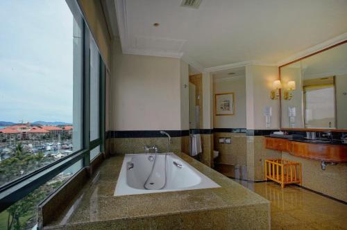 a bathroom with a large bath tub with a large window at The Pacific Sutera Hotel in Kota Kinabalu