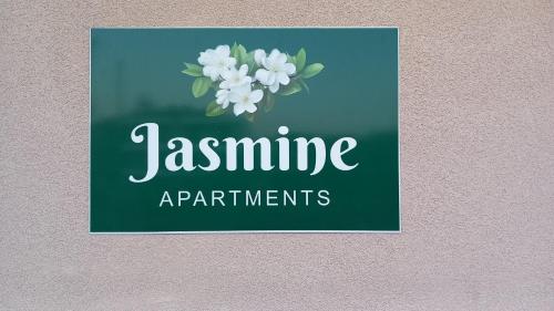a sign that says jasmine apartments with white flowers at Jasmine Apartments in Lefkada Town