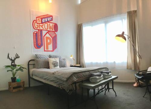 a bedroom with a bed and a large window at Character Apartment in Central Downtown Auckland in Auckland
