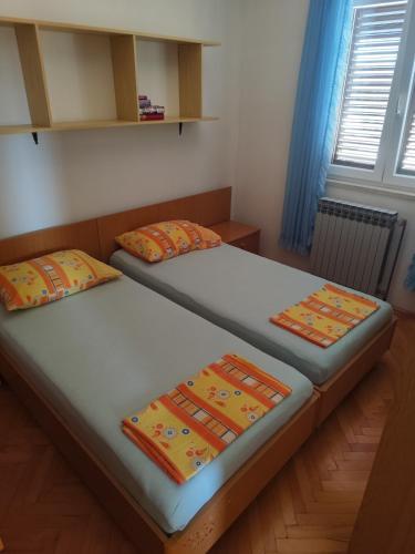 two twin beds in a room with blue curtains at Apartments Celine & Fabienne in Brodarica