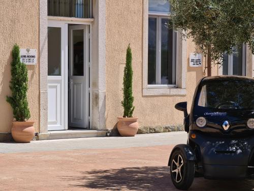 a small blue car parked in front of a building at Hotel Stara šola - Oleander Resort in Izola