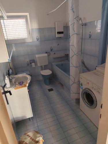 a bathroom with a sink and a toilet and a tub at Apartments Celine & Fabienne in Brodarica