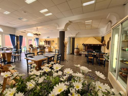 a restaurant with tables and white flowers in the middle at Hotel Stara šola - Oleander Resort in Izola