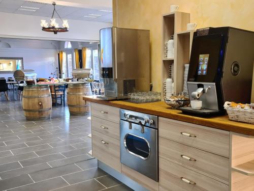 a kitchen with a counter with a stove and appliances at Hotel Stara šola - Oleander Resort in Izola