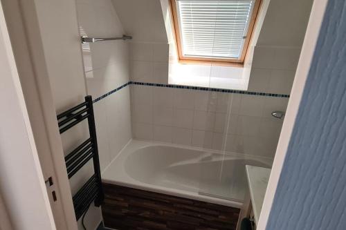 een badkamer met een bad en een raam bij Maison de vacances in Saint-Nic