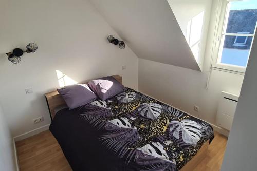 een slaapkamer met een bed met een zwart dekbed bij Maison de vacances in Saint-Nic