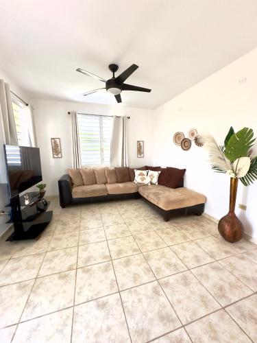 a living room with a couch and a ceiling fan at La Casandra Beach House in Isabela